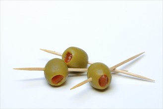 Green olives on toothpicks, stuffed with pieces of paprika