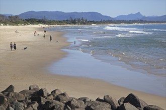 Tourists strolling on the beach at Byron Bay along the Coral Sea, New South Wales, Australia,