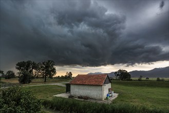 Dark storm clouds over a small barn, windy, Schlehdorf, Bavaria, Germany, Europe