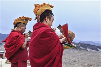 THIKSEY, INDIA, SEPTEMBER 4, 2011: Two Tibetan Buddhist monks blowing conches during morning pooja,