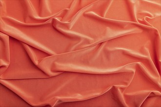 Fragment of red silk tissue. Top view, natural textile background and texture. wave concept,