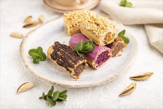 Set of eclair, traditional french dessert and cup of coffee on gray concrete background and linen