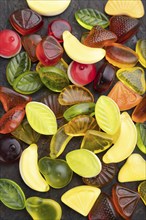 Various fruit jelly candies on black concrete background. top view, flat lay, close up