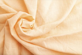 Fragment of orange linen tissue. Top view, flat lay, natural textile background and texture. wave