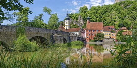 Panoramic view of the ancient stone bridge over the river Naab with the church tower of St Michael