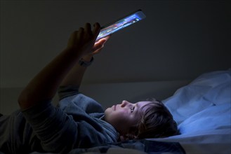 A boy plays computer games on a tablet PC