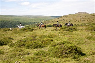 People riding horses by Sharp Tor, Dartmoor national park, Devon, England, UK