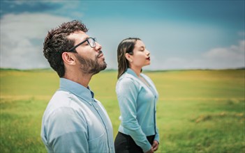 Young couple breathing fresh air in the field. Two relaxed people breathing fresh air in the