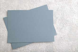 Blue paper business card, mockup on gray concrete background. Blank, flat lay, top view, still