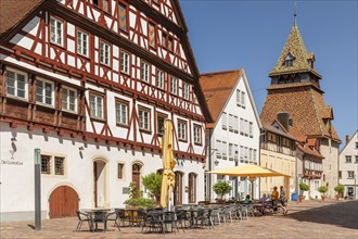 Street cafes and bell tower behind the Heilig Kreuz Münster, Schwäbisch Gmünd, Baden-Württemberg,