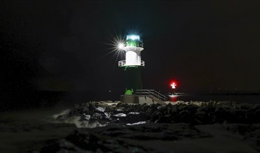 A lighthouse on the pier shows ships the way to Rostock harbour, Warnemünde, 09.02.2023