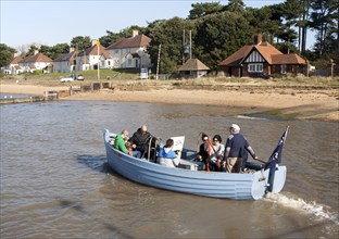 Small ferry boat crossing River Deben between Bawdsey Quay and Felixstowe Ferry, Suffolk, England,