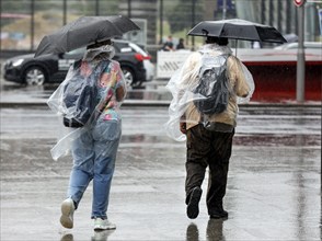 Tourists with rain capes and umbrellas during heavy rainfall, Berlin, 23 06 2023