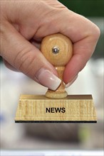 Symbol photo, woman's hand with stamp, inscription: News, Studio