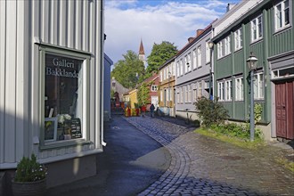 Narrow alley with historic buildings and cobblestones in the old town centre, Nidarelva, Trondheim,