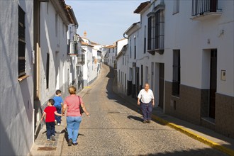 People walking along a quiet street in village of Jabugo, Sierra de Aracena, Huelva province,