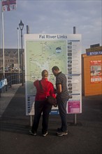 People looking at a map of River Fal transport links Prince of Wales pier, Falmouth, Cornwall,