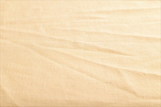 Fragment of smooth orange linen tissue. Side view, natural textile background and texture