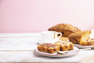 Homemade cake with raisins, almonds, soft caramel on a white and pink background. Side view,