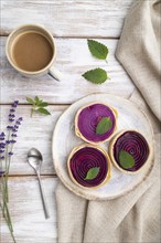 Sweet tartlets with jelly and milk cream with cup of coffee on a white wooden background and linen