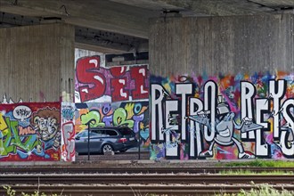 Colourful graffiti on a concrete wall in a subway with parked cars, Rhineland-Palatinate, Germany,