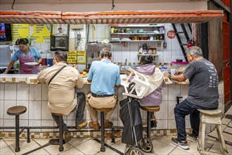 Visitors sitting at a food stall at the counter, Mercado Central de San José, San José, Costa Rica,