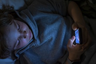 A boy plays computer games on a mobile phone, smartphone