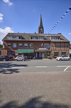 Weseler Strasse with building and church tower of St. Pankratius in the Buldern district, Dülmen,