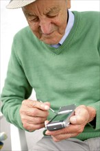 A senior citizen talking on his smartphone, mobile phone, mobile phone, 65 years old, studio