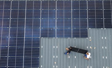 Installation of solar modules on the roof of a barn on a farm, over 210 photovoltaic modules are