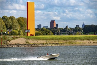 The sculpture Rhine Orange at the mouth of the Ruhr into the Rhine, skyline of the city centre of