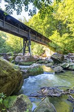 The Irrel Waterfalls, rapids in the lower reaches of the Prüm, covered wooden bridge for hikers,