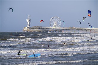 The pier and Ferris wheel at Scheveningen beach, strong swell, windsurfers, kitesurfers, surfers,