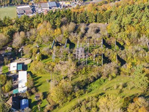 A high ropes course in the middle of an autumn-coloured forest, visible from above, high ropes