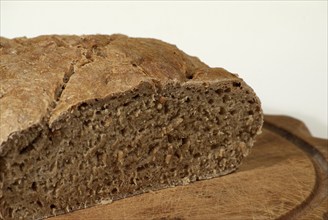 Bread loaf, grey bread, cut, on wooden board