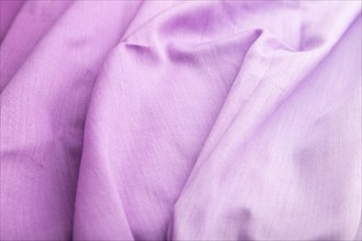 Fragment of cotton purple tissue. Side view, natural textile background and texture. wave concept,