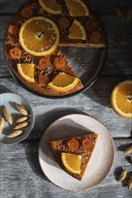 Orange cake on a gray wooden background. Hard light. contrast, low key. Top view, flat lay, close