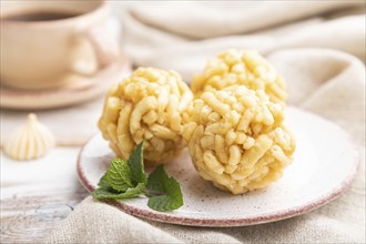 Traditional Tatar candy chak-chak made of dough and honey with cup of coffee on a white wooden