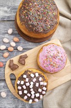 Homemade glazed and decorated easter pies with chocolate eggs and rabbits on a gray wooden