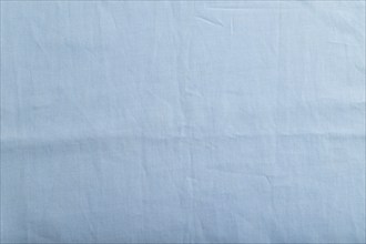 Fragment of smooth cotton blue tissue. Top view, flat lay, natural textile background and texture