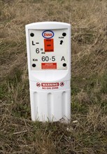 Close up of Esso gas pipeline under surveillance marker warning no dig zone, Salisbury Plain,