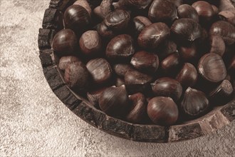 Fresh chestnuts, in a wooden bowl, top view, no people