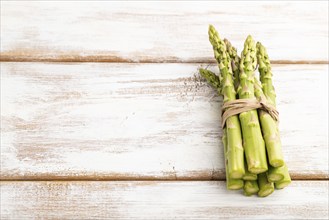 Bunch of fresh green asparagus on white wooden background. Side view, copy space. harvest, healthy,