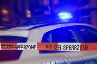 Symbolic image: Police cordon at night with a police car behind it (Composing)