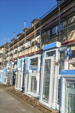 Energy-efficient refurbishment of residential buildings, older apartment block is scaffolded, gets