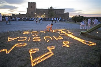 Castilian boy lighting candles, Pedraza Castle in the background, Conciertos de las Velas festival