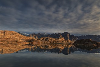 Mountains and rocks reflected in fjord, midnight sun, mood, Scoresby Sound, East Greenland,