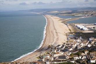 Chesil beach tombolo with housing in Chiswell in the foreground, Isle of Portland, Dorset, England,