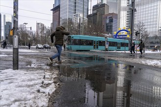 Winter in the city, Gallusanlage street, puddles, pools of water, melt water, pedestrians,