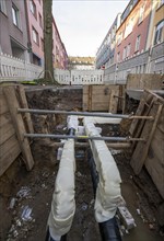 Construction site of a district heating house connection, pipes, insulated, are laid from a central